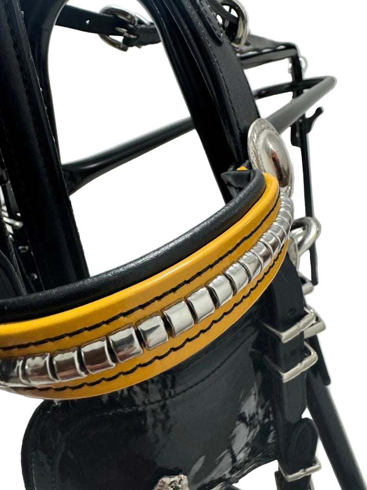 Close-up of a black and yellow helmet with a metallic band on a white background