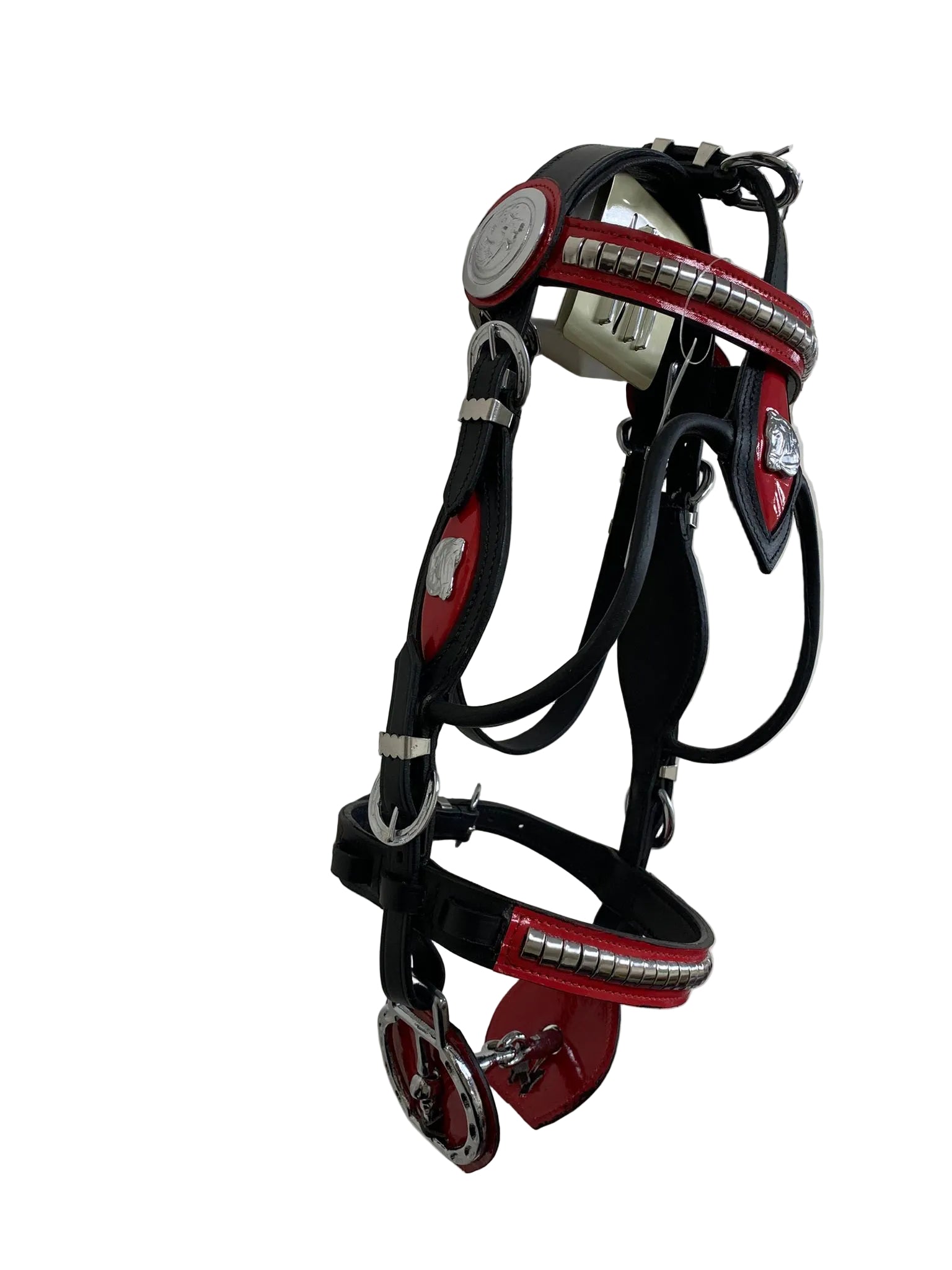 Black and red horse bridle with metallic accents on a white wall.
