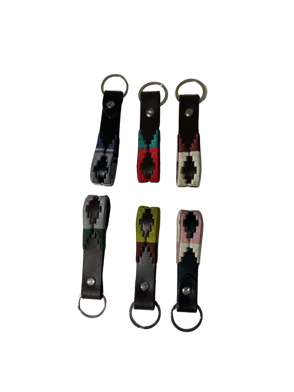 Set of six colorful keychains with geometric patterns on a white fabric background