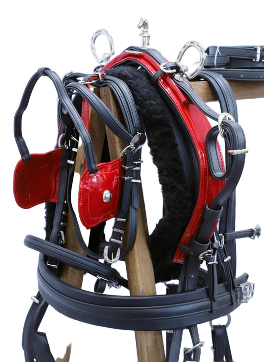 Red and black equestrian harness on a stand against a white background